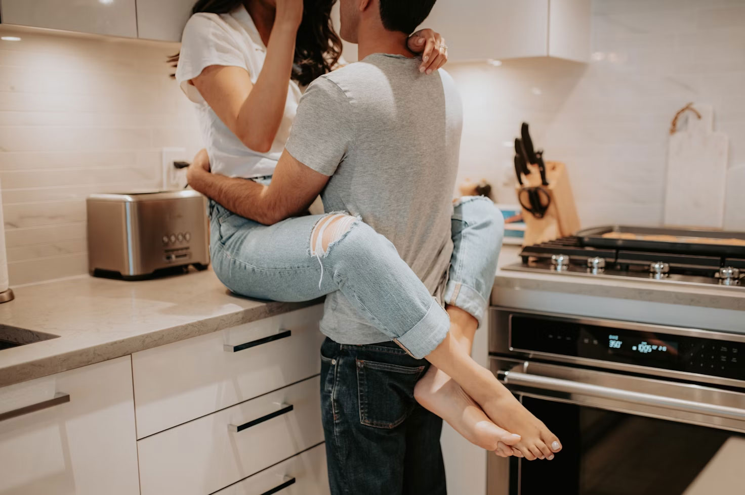 dating couple holding each other in a kitchen